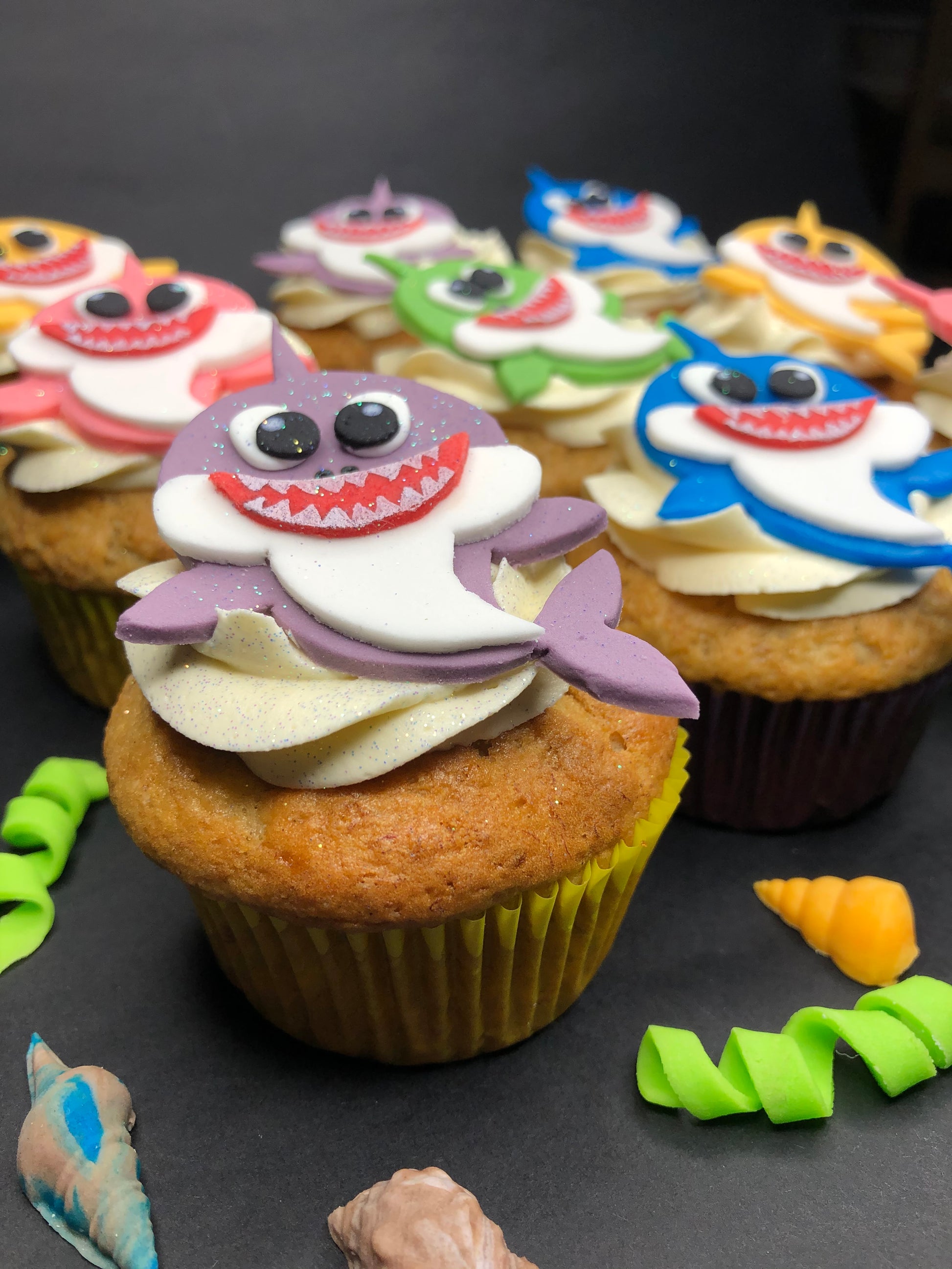 Cupcakes decorated with shark-themed toppers 