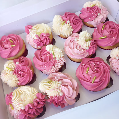 Decorative cupcakes with pink and white frosting in a box