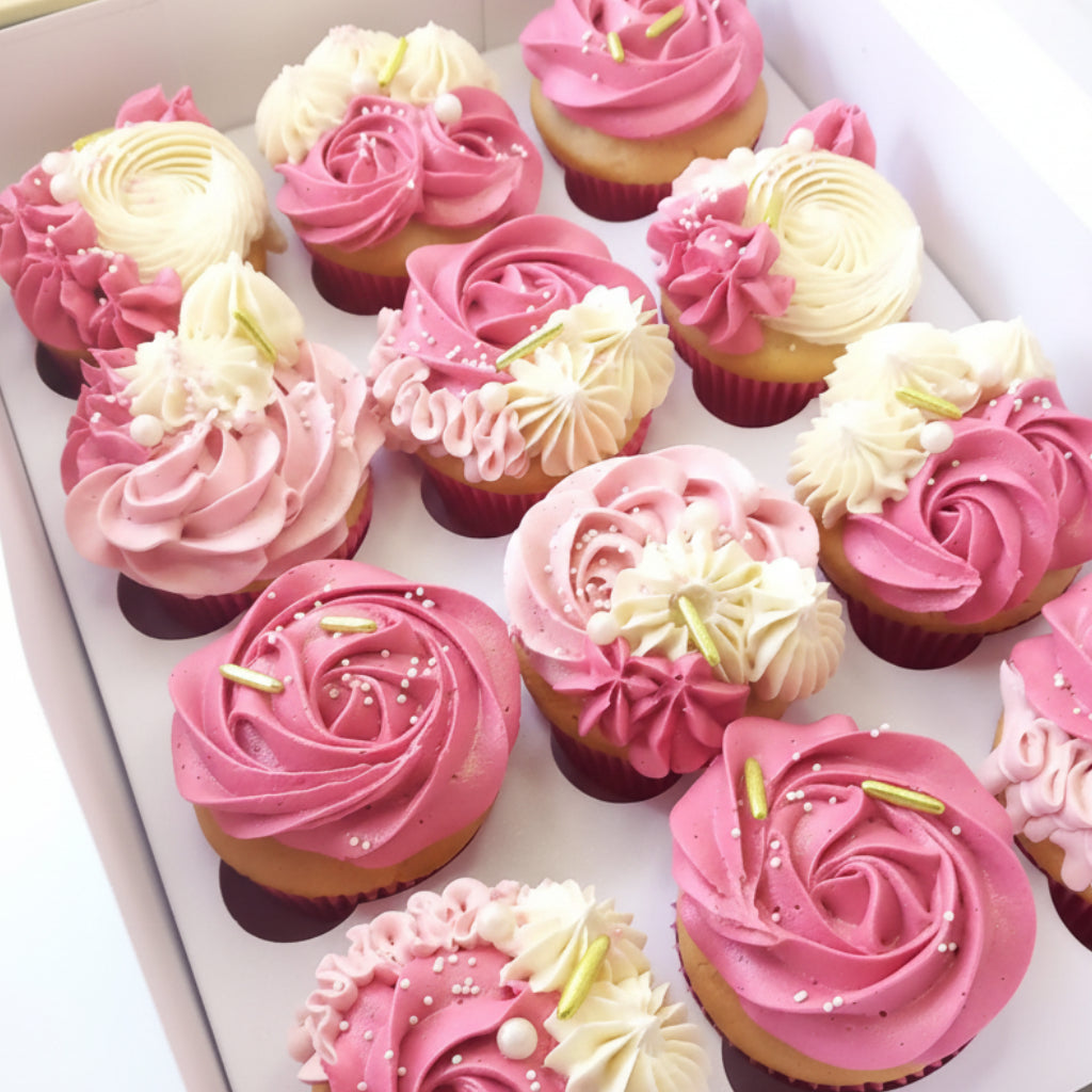 Box of cupcakes with pink and white frosting