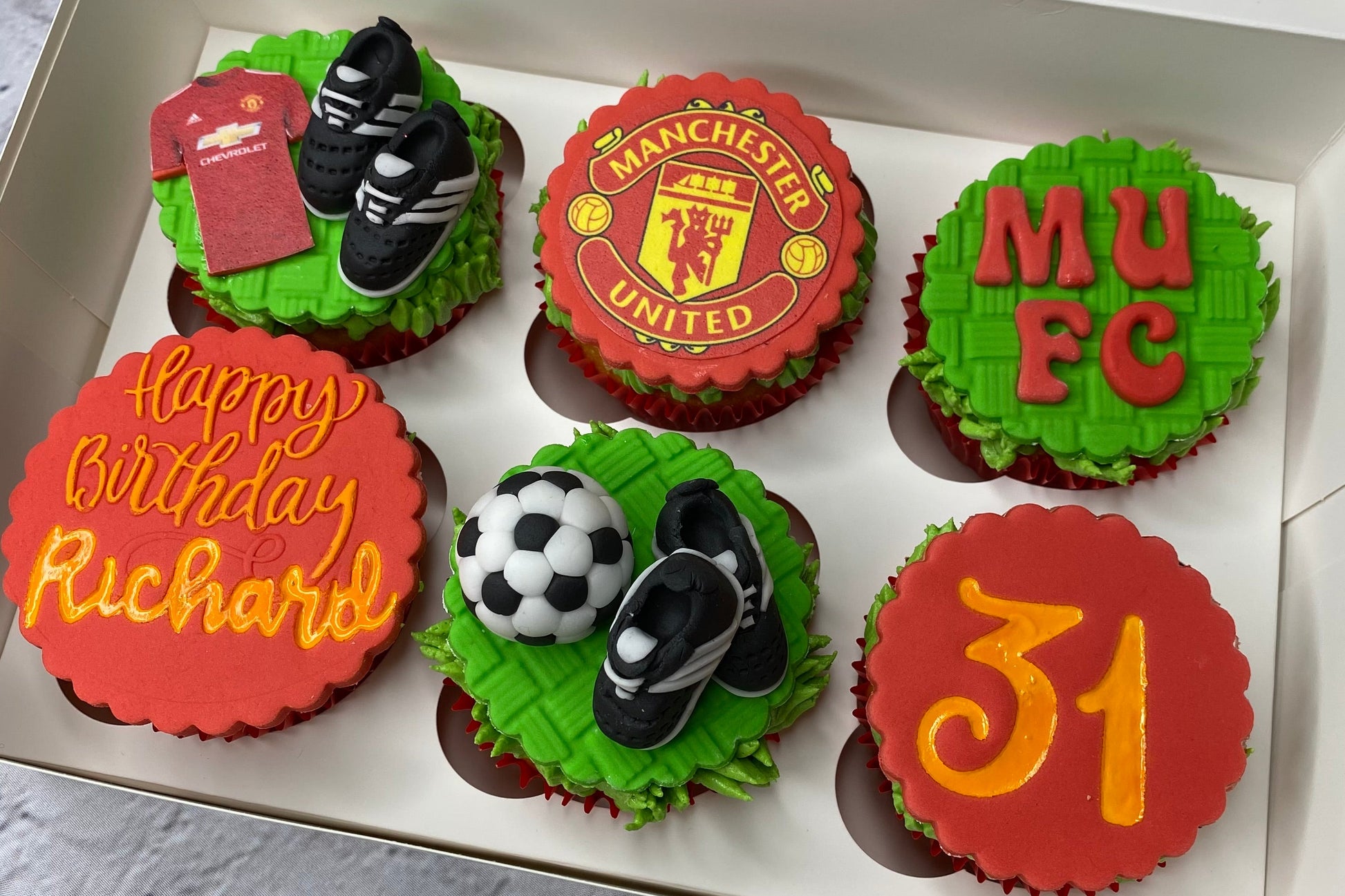 Box of cupcakes decorated with Manchester United theme and 'Happy Birthday
