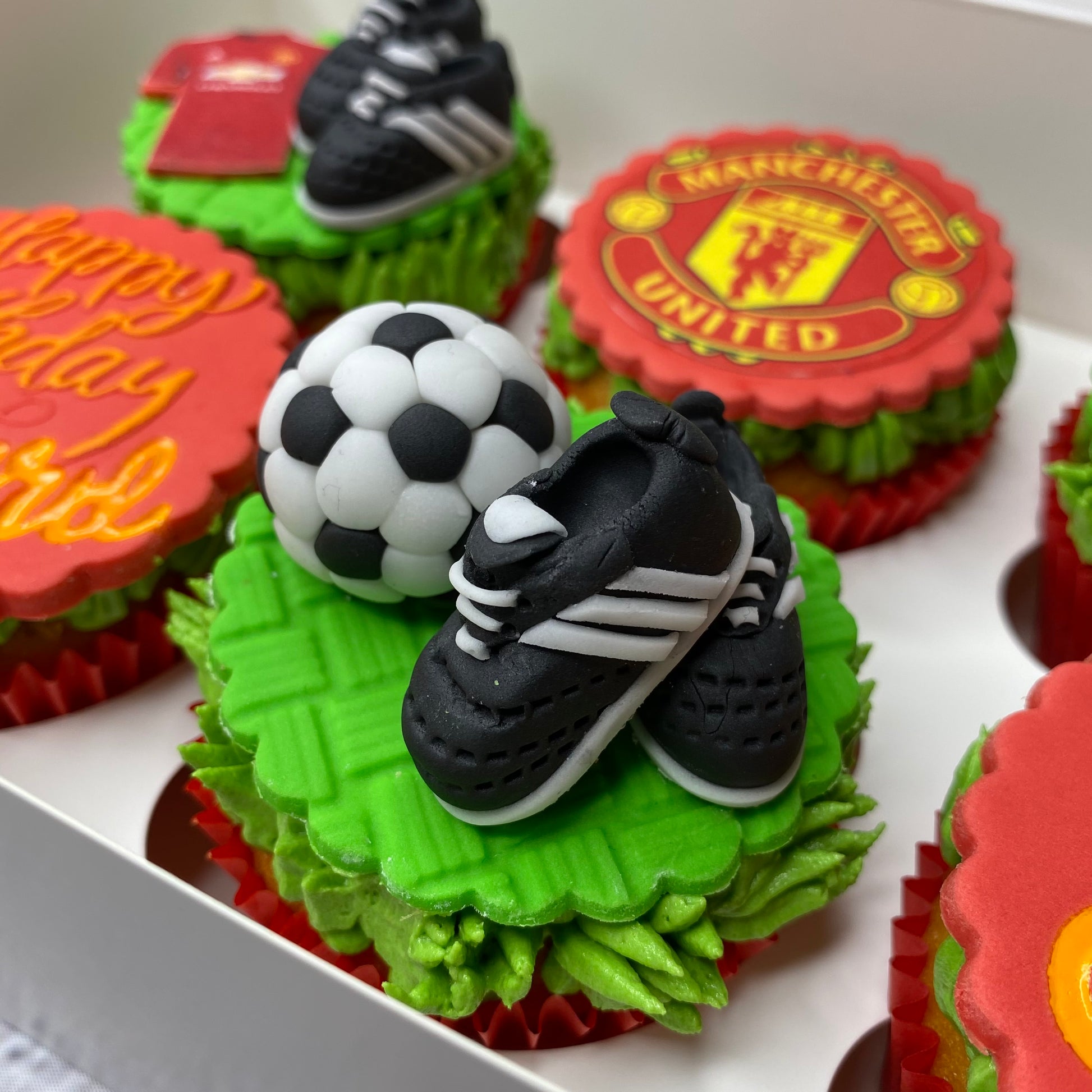 Cupcakes decorated with Manchester United logo and soccer elements