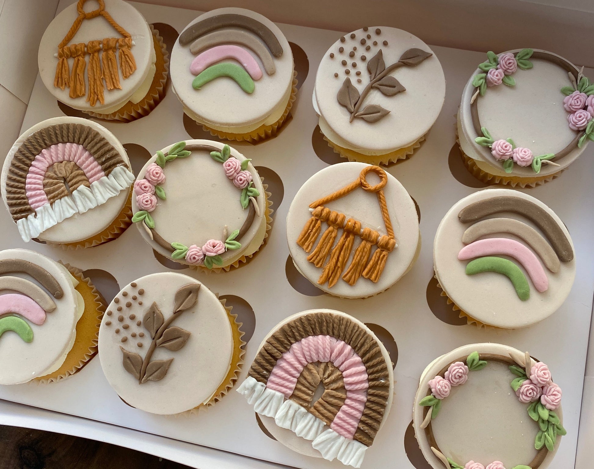 Decorative cupcakes with intricate designs in a box