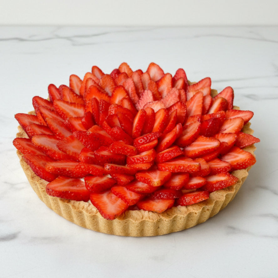 Strawberry tart with a decorative arrangement of sliced strawberries on a white background